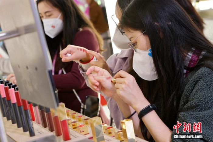 圖為女生正在體驗(yàn)口紅產(chǎn)品。 殷立勤 攝