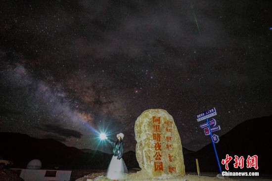 圖為6月20日晚，游客“打卡”西藏阿里暗夜公園，天上是銀河與流星（右上角）。曹枝清 攝