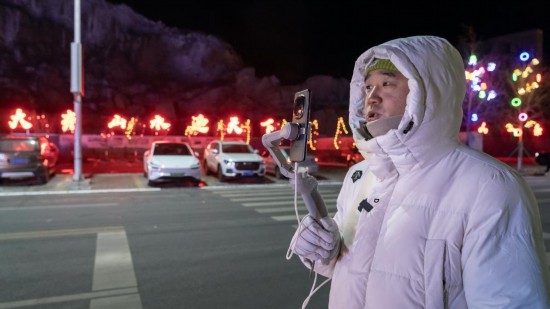 在吉林市阿什哈達(dá)霧凇觀景帶，霧凇播報(bào)員正在直播。新華社記者 李典 攝