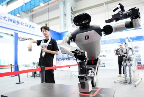 9月5日，在沈陽的2025全球工業(yè)互聯(lián)網(wǎng)大會(huì)的展覽區(qū)現(xiàn)場(chǎng)，中國(guó)科學(xué)院沈陽自動(dòng)化研究所的機(jī)器人工程師在調(diào)試具身智能操作系統(tǒng)。新華社記者 李鋼 攝