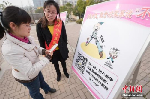 資料圖：今年3月8日，安徽合肥新華社區(qū)志愿者夏一瓊(右)向市民普及反家暴相關法律知識。鐘欣 攝