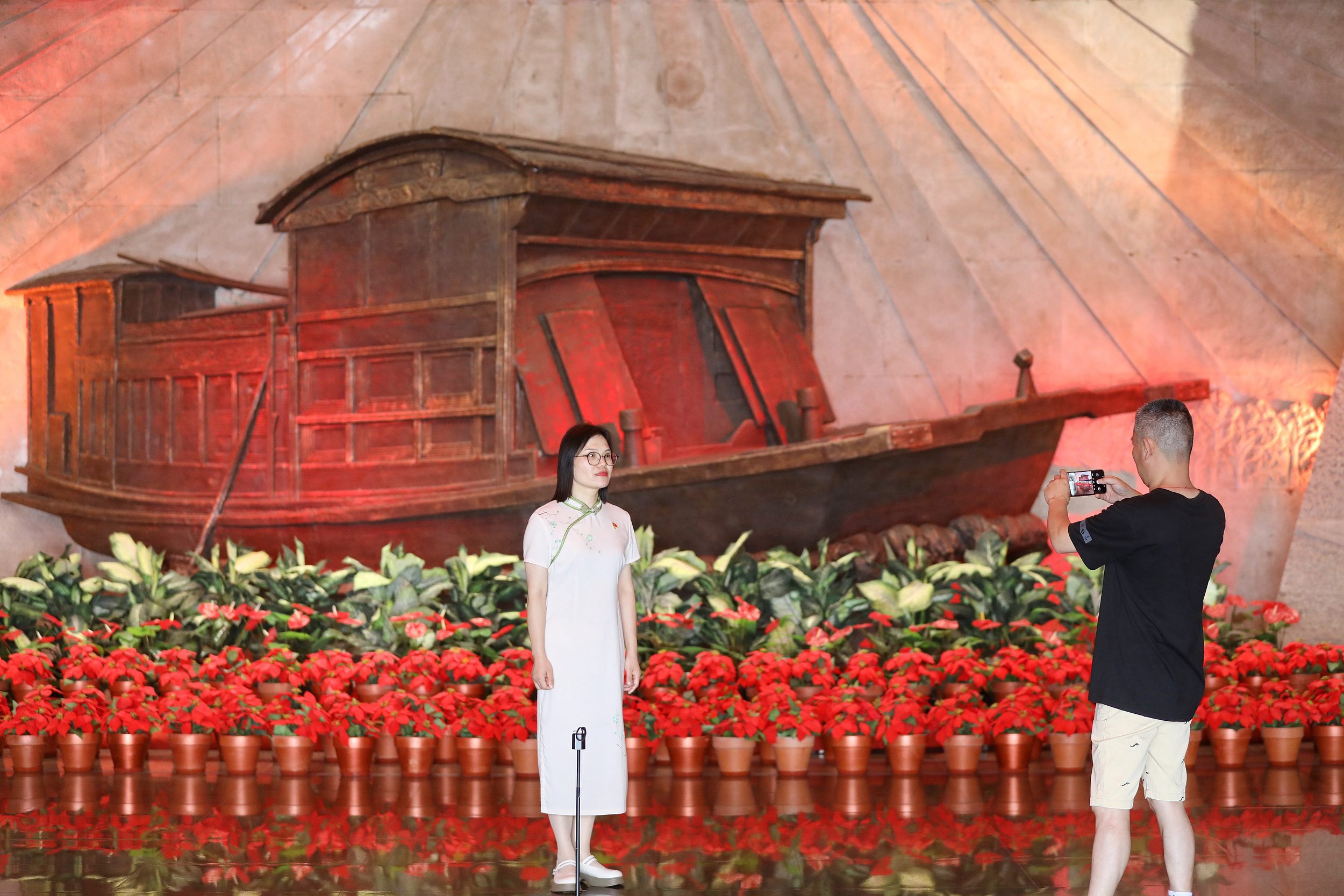 2025年6月24日，浙江嘉興，游客在南湖革命紀念館與紅船雕塑合影。（圖片來源：視覺中國）