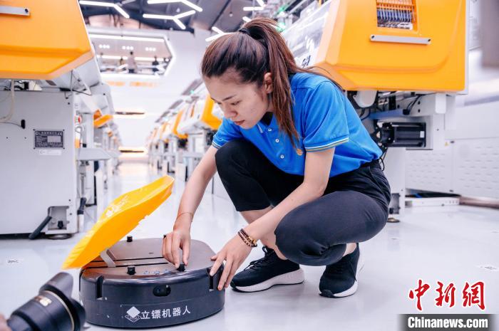 圖為員工在調(diào)試AGV搬運(yùn)機(jī)器人?！±钅宪?攝